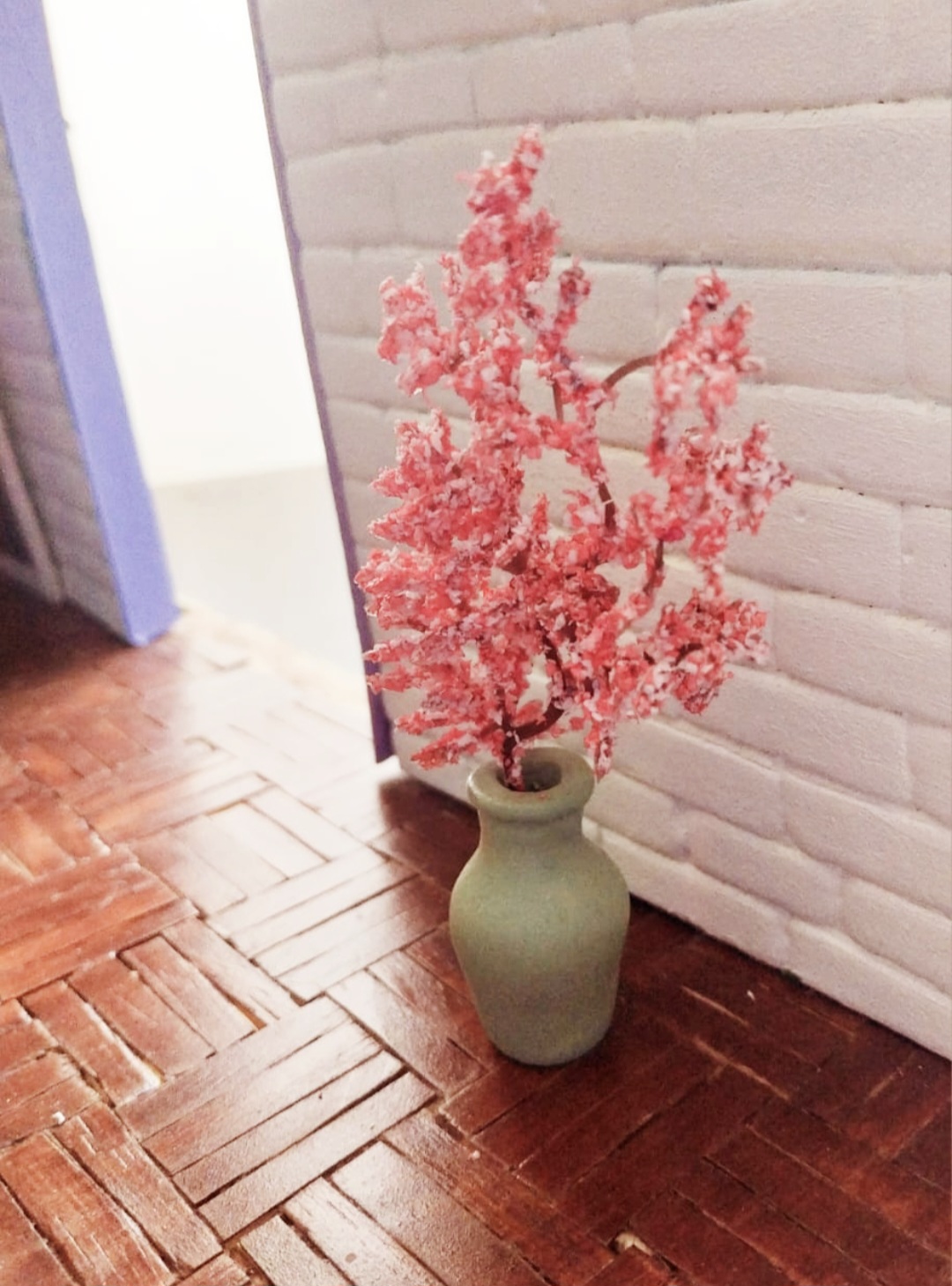Macro de mini galho de cerejeira em flor em vaso artesanal no atelier Madame Blum